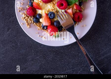 Metà di un piatto dall'alto con frutta fresca e. Budino proteico Foto Stock