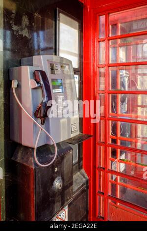 All'interno della scatola telefonica pubblica rossa con telefono a pagamento Foto Stock