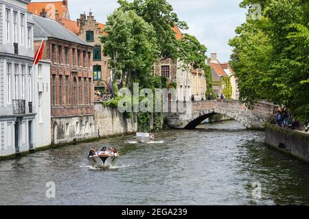 Turisti che visitano le imbarcazioni da diporto sul canale Groenerei a Bruges, Belgio Foto Stock