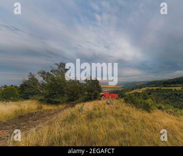 Panorama di pomeriggio nuvoloso in montagna con tetto rosso edificio Foto Stock