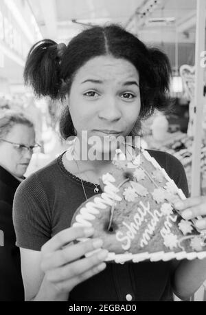 Porträt der deutschen Schlager- Disco- und Popsängerin Ramona Wulf während sie an einem Lebkuchenherz abbeißt, Deutschland ca. 1972. Ritratto della cantante pop, discoteca e pop tedesca Ramona Wulf mentre ha un cuore di pan di zenzero, Germania circa 1972. Foto Stock