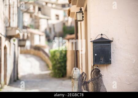 Letterbox vintage sul muro, strada stretta sullo sfondo Foto Stock