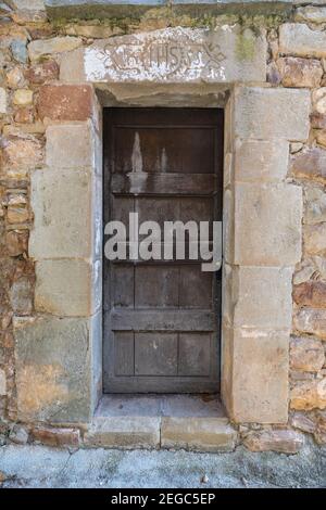 Vecchia porta rustica e un Christogram 'IHS' intagliato sulla arco Foto Stock