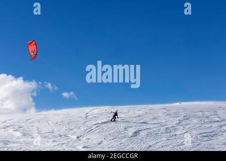 Kite sciare in cima alla montagna con aquiloni sulla neve Foto Stock