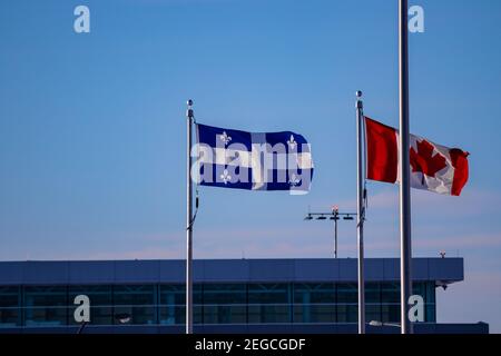 Québec e la bandiera canadese che battono nel vento all'aeroporto di Quebec City. Foto Stock