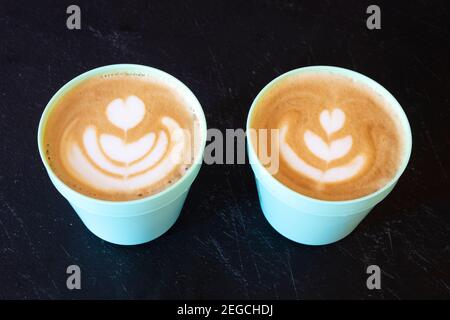 Due tazze di caffè su sfondo nero. Foto Stock