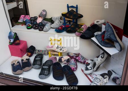 Pantofole in vendita in un negozio, freddo inverno. Vendita di pantofole per la casa, per bambini e adulti. Felici i piedi caldi in inverno Foto Stock