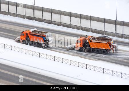 Allineati spazzaneve rimuovere la neve l'autostrada su un Giorno invernale freddo innevato Foto Stock