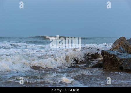 Vista panoramica sulle onde marine schiumose del Mar Arabico che si infrangono sulle rocce di Gokarna Main Beach o Middle Beach sulla costa occidentale di Gokarna, Foto Stock