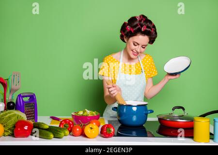 Foto vintage ragazza alla moda cucinare deliziosa cena pasta bollire salsa pan godetevi il tavolo da cucina, il pomodoro cetriolo, il tempo libero e il giallo alla moda capelli di abito punteggiato Foto Stock