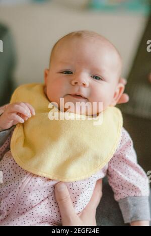 Bambina di tre mesi tenuta dalla madre Foto Stock
