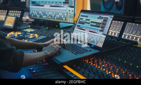 Modern Music Record Studio Control Desk con schermo per laptop che mostra l'interfaccia utente del software Digital Audio Workstation. Equalizzatore, miscelatore e. Foto Stock