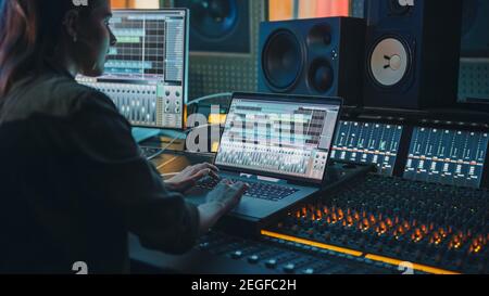 Modern Music Record Studio Control Desk con schermo per laptop che mostra l'interfaccia utente del software Digital Audio Workstation. Equalizzatore, miscelatore e. Foto Stock