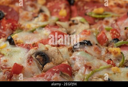 Pizza con ingredienti misti e formaggio fuso sulla parte superiore Foto Stock