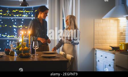 Multi generazioni di belle donne che preparano e servono la cena in cucina. Nonna, figlia hanno divertimento, cucinare insieme, parlare, condividere Foto Stock