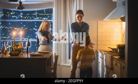 Multi generazioni di belle donne che si preparano e ballano in cucina. Nonna, figlia e nipote carino hanno divertimento, cucina Foto Stock