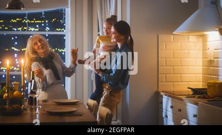 Multi generazioni di belle donne che preparano e servono la cena in cucina. Nonna, figlia e nipote carino hanno divertimento, cucina Foto Stock