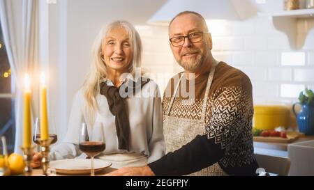 Happy Senior Couple in Love hanno una serata romantica, sorridendo sulla fotocamera e festeggiando l'anniversario. Gli anziani hanno una serata romantica con vino, festivo Foto Stock