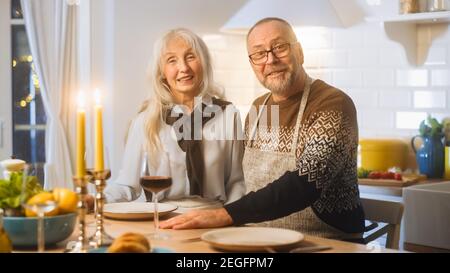 Happy Senior Couple in Love hanno una serata romantica, sorridendo sulla fotocamera e festeggiando l'anniversario. Gli anziani hanno una serata romantica con vino, festivo Foto Stock