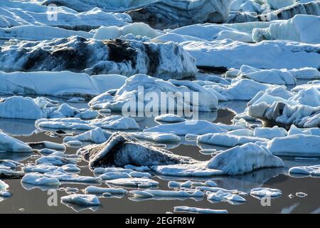 Ghiaccio galleggia nel lago glaciale di Fjallsarlon in una serata estiva, Islanda Foto Stock