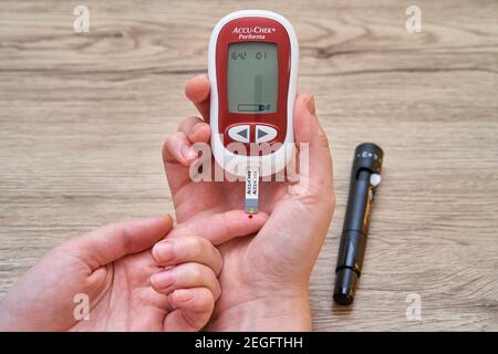 Test medico pazienti un livello di glucosio dopo la puntura il suo dito per  disegnare una goccia di sangue e quindi usando un glycometer digitale Foto  stock - Alamy