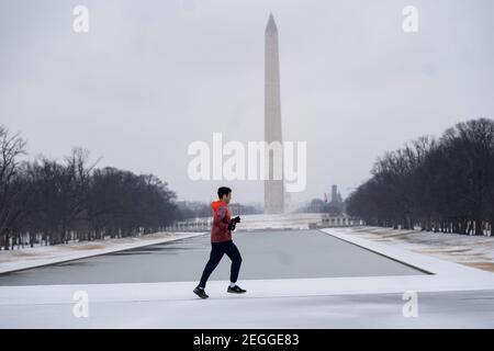 Washington, Stati Uniti. 18 Feb 2021. Un uomo scherza vicino al Washington Monument a Washington, DC, Stati Uniti, il 18 febbraio 2021. Credit: Liu Jie/Xinhua/Alamy Live News Foto Stock