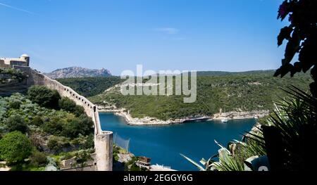 Blu e turchese mare Mediterraneo sotto i bastioni della Cittadella medievale della città di Bonifacio Foto Stock