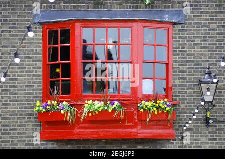 Finestra in legno rosso in stile georgiano su brickwall di Southwark, Londra Foto Stock