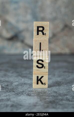 Rischio di scrittura con lettere nere su morse di legno sul sfondo in marmo Foto Stock