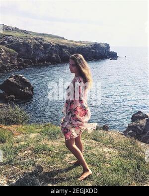 Primo piano di una giovane donna che indossa un abito estivo al mare Foto Stock