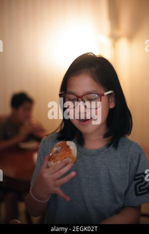 Una ragazza che mangia panna fatta in casa Foto Stock