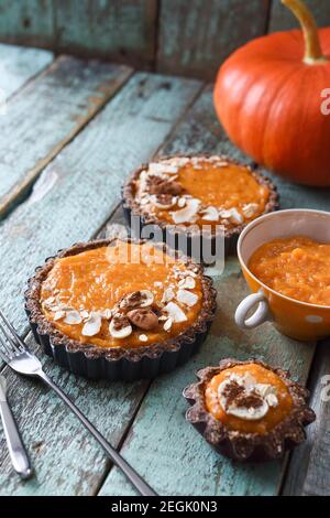 Dolci vegetariani fatti in casa. Purea di zucca e torte di zucca aperte su sfondo blu shabby copyspace Foto Stock