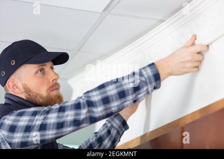 elettricista maschio che controlla la tensione della presa Foto Stock