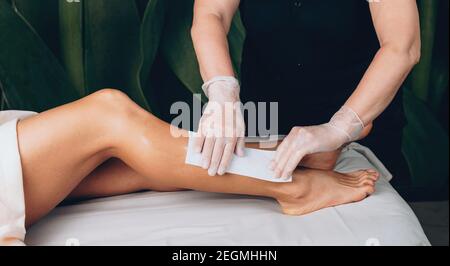 Vista laterale foto di una donna caucasica che ha un centro termale procedura di depilazione dei capelli delle gambe Foto Stock