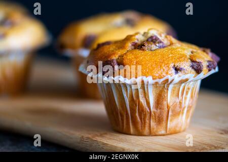 Muffin al cioccolato appena sfornati su un piatto di legno Foto Stock