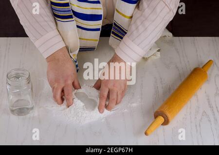 L'uomo ebreo ortodosso prepara a mano kosher piatto matzah per cottura Foto Stock