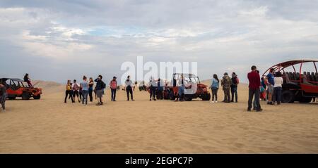 Perù, Ica - 21 settembre 2019 - Panoramica di molti turisti e buggy nel deserto di Huacachina Foto Stock