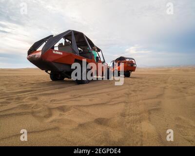 Perù, Ica - 21 settembre 2019 - Buggies arancione nel deserto vicino all'oasi di Huacachina Foto Stock