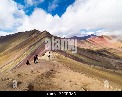 Perù, Vinicunca - 27 settembre 2019 - Vista panoramica completa della montagna arcobaleno, turisti sullo sfondo Foto Stock