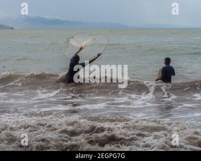 Puerto Viejo, Costa Rica - 30 novembre 2019 - due amici che pescano con reti all'interno dell'acqua Foto Stock