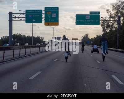 USA, Miami Gardens - 15 dicembre 2019 - quattro motociclisti in autostrada, due dei quali fanno le ruote Foto Stock