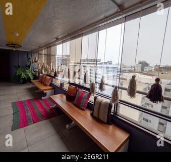 Peru, Lima - 28 settembre 2019 - Bancali con cuscini di colore luminoso accanto alla finestra di vetro Foto Stock