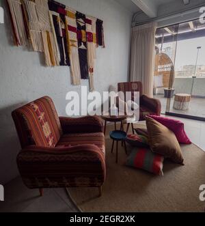 Perù, Lima - 28 settembre 2019 - sedie colorate e arredamento all'interno della camera a Selina ostello, mucchio di cuscini sul pavimento Foto Stock