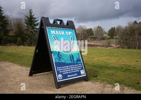 Il cartello Mask Up è visibile sui sentieri del Woodmont Park, inaugurato di recente, nel lago Oswego, Oregon, il 7 febbraio 2021, in mezzo alla pandemia del coronavirus. Foto Stock