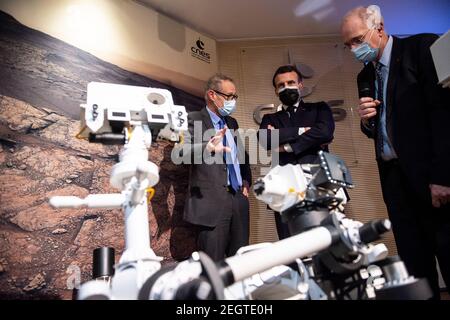 Parigi, Francia. 18 Feb 2021. Il presidente francese Emmanuel Macron, affiancato dal presidente della CNES francese, Jean-Yves le Gall (R) e l'astrofisico francese e creatore di Supercam Sylvestre Maurice (L) guardano ad un modello 3D dello strumento Supercam esposto al Centro Nazionale Francese per gli Studi spaziali (CNES) durante una visita per assistere allo sbarco della perseveranza della NASA Mars rover sul pianeta Marte, A Parigi il 18 febbraio 2021. Credit: Abaca Press/Alamy Live News Foto Stock