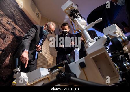 Parigi, Francia. 18 Feb 2021. Il presidente francese Emmanuel Macron, affiancato dal presidente della CNES francese, Jean-Yves le Gall (R) e l'astrofisico francese e creatore di Supercam Sylvestre Maurice (L) guardano ad un modello 3D dello strumento Supercam esposto al Centro Nazionale Francese per gli Studi spaziali (CNES) durante una visita per assistere allo sbarco della perseveranza della NASA Mars rover sul pianeta Marte, A Parigi il 18 febbraio 2021. Credit: Abaca Press/Alamy Live News Foto Stock