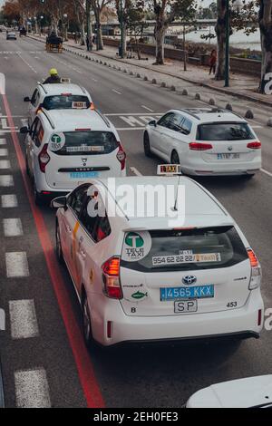 Siviglia, Spagna - 19 gennaio 2020: Taxi su una strada a Siviglia, capitale della regione dell'Andalusia nel sud della Spagna e una popolare destinazione turistica. Foto Stock