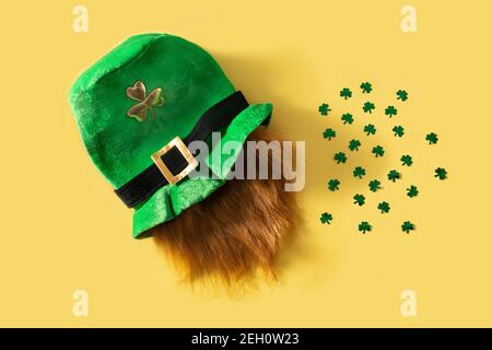 Cappello e trifogli di San Patrizio su sfondo giallo Foto Stock