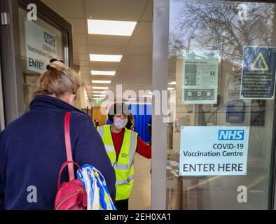 Un centro governativo di vaccinazione Covid-19 con personale che aiuta il pubblico selezionato per la loro vaccinazione. Foto Stock