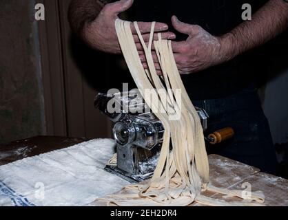 Pasta tradizionale che prepara il passato fresco con una macchina a mano d'annata Foto Stock